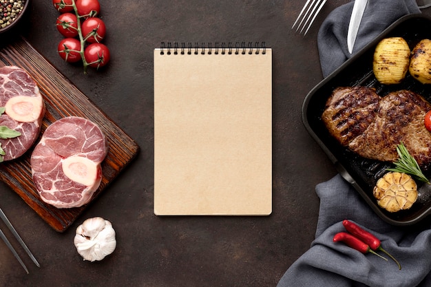 Free photo notebook and meat prepared to be cooked