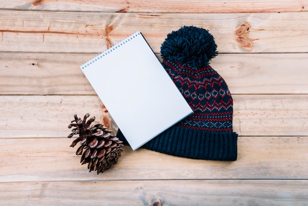 Notebook near bobble hat 