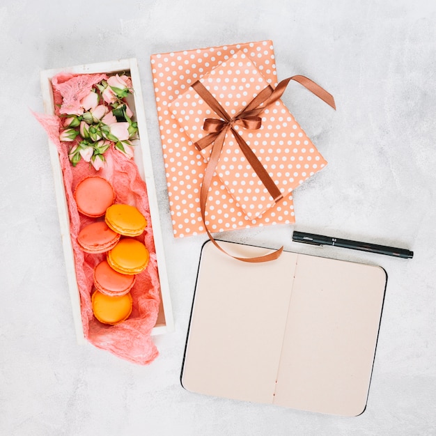 Notebook and pen near dessert and presents