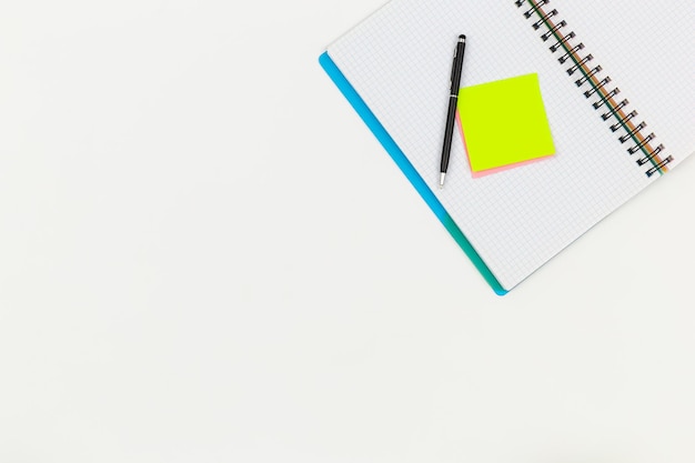 Free photo notebook pen and paper colored reminders on a white background