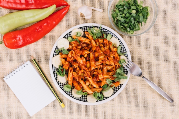 Free photo notebook and pepper near pasta