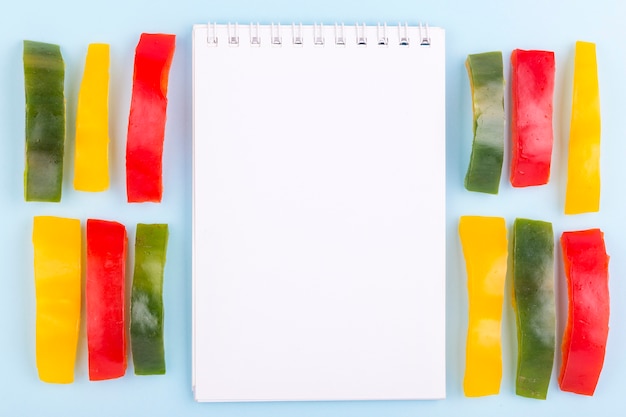 Notebook surrounded by bell peppers