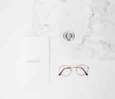 Free photo notebook text on paper; coffee cup and eyeglasses on white texture backdrop