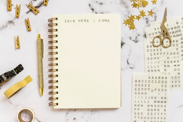 Notebook with 2019 here I come inscription near set of stationery