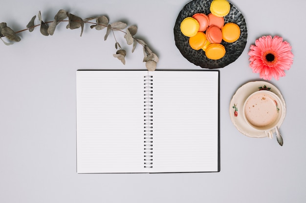 Free photo notebook with cookies and flower on table