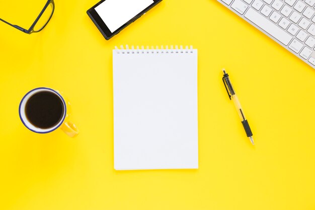 Notebook with cup and pen on colorful desk