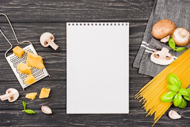 Notebook with ingredients for spaghetti with mushrooms