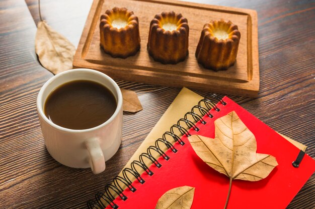 Notebooks and coffee near pastry