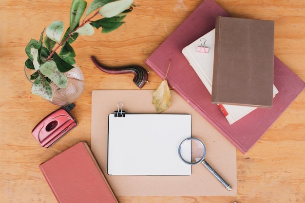 Notebooks near vase with twig