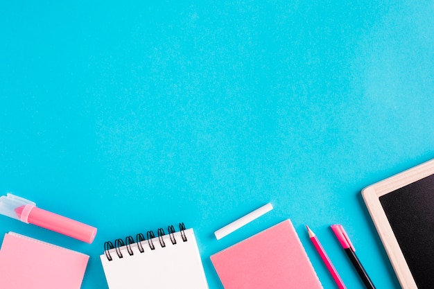 Notebooks and stationery on colored background