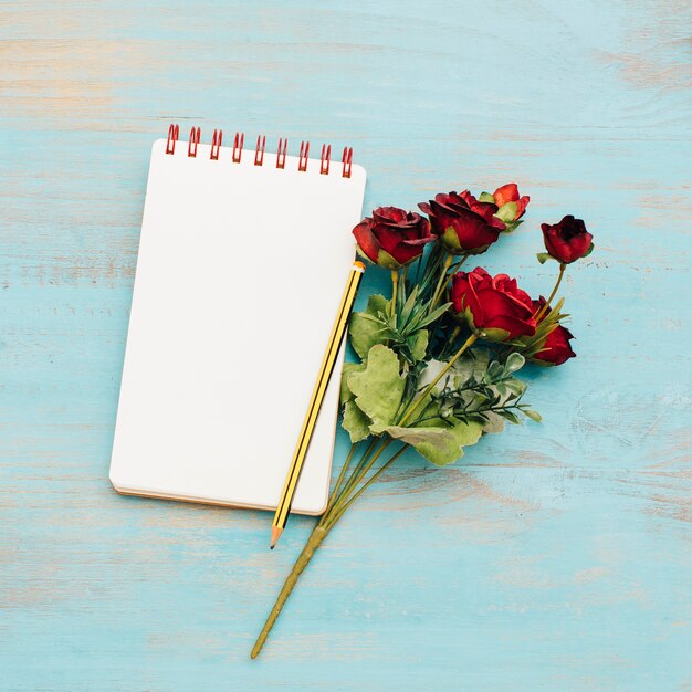 Free Photo notepad with bouquet of roses.