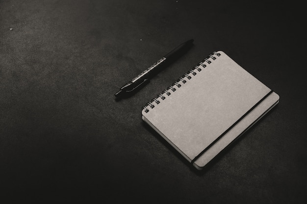 A notepad with a pen on a dark background