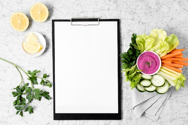 Free photo notepad with plate of vegetables and lemon