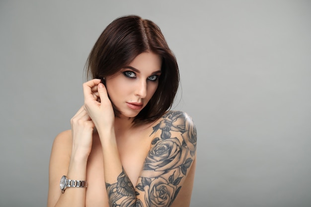 Free photo nude woman with tattoo posing