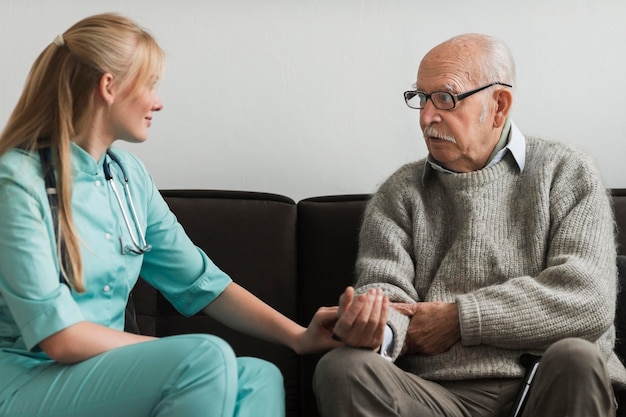 Nurse consoling old man in a nursing home