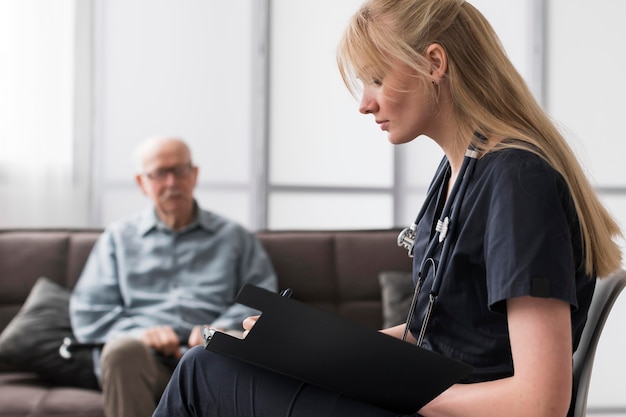 Nurse consulting old man in a nursing home