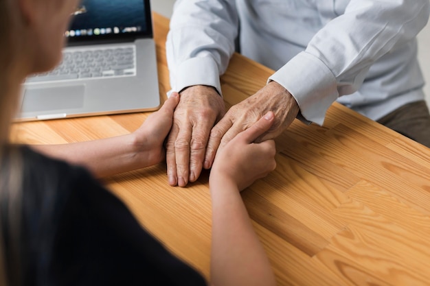 Nurse holding senior man's hands for relief