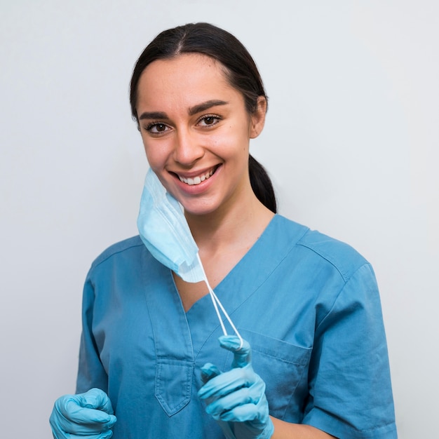 Free photo nurse taking off a medical mask