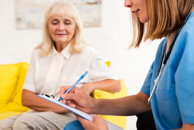 Free photo nurse writing on clipboard close-up