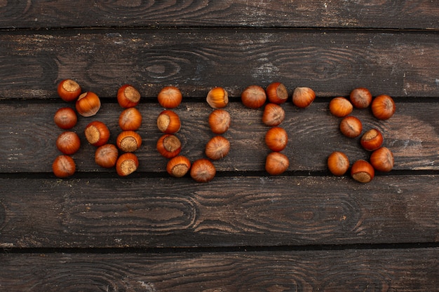 Nuts brown ripe nuts word shaped on a brown wooden desk