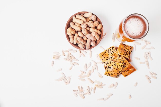 Nuts and crackers with beer on white.