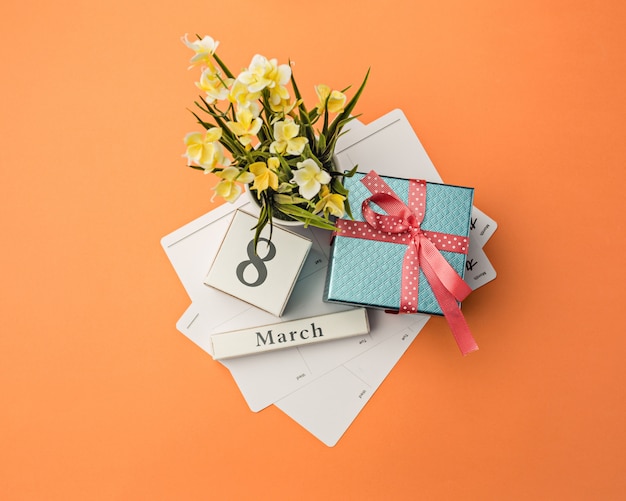 Oange desk with gift, flowers and notebook