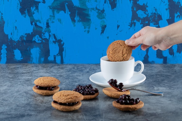 Oatmeal cookies with blackcurrant berries confiture served with a cup of tea