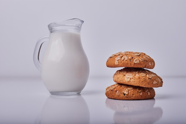 Oatmeal crackers served with a jar of milk on grey.