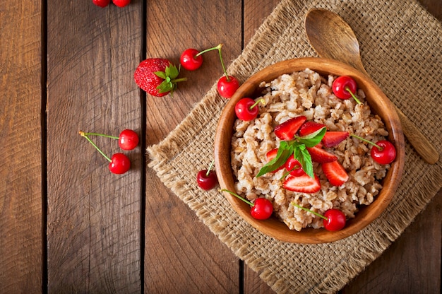 Oatmeal porridge with berries in a white bowl