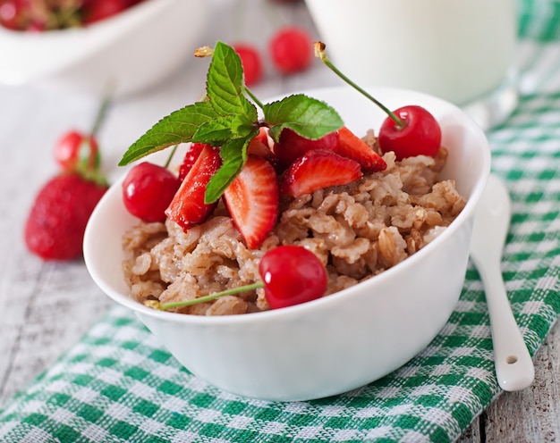 Free Photo oatmeal porridge with berries in a white bowl