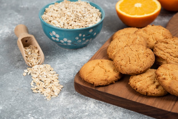 Oatmeal with homemade cookies over grey table.