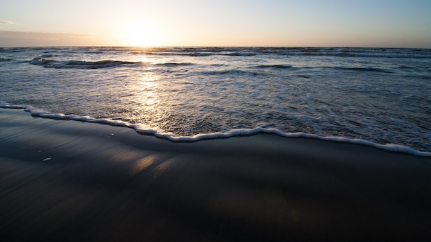 Ocean beach with light waves over the sand