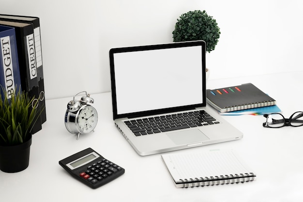 Office desk surface with laptop and notebook