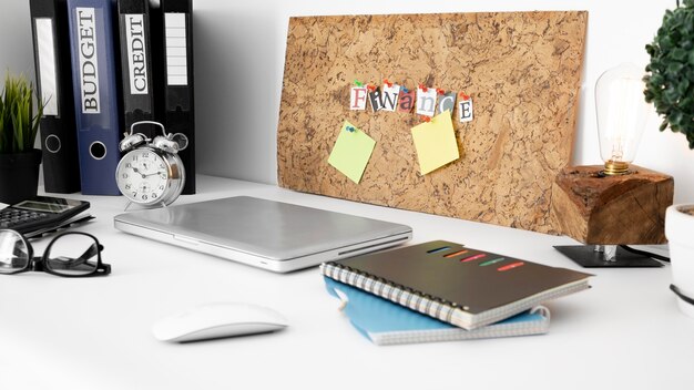 Office desk surface with notebooks and laptop