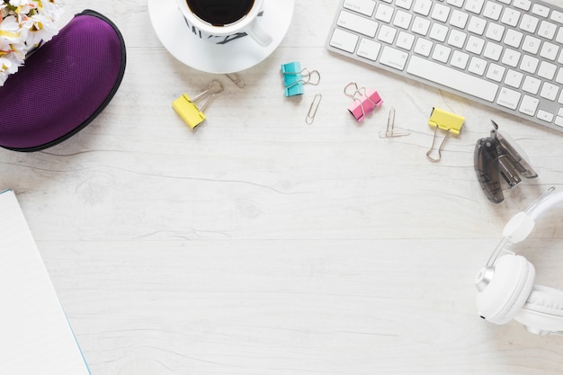 Free photo office supplies; coffee cup; headphone and keyboard on white desk