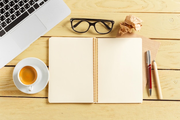 Office table background with coffee cup, pencils and computer keyboard. Business workplace or workspace concept.