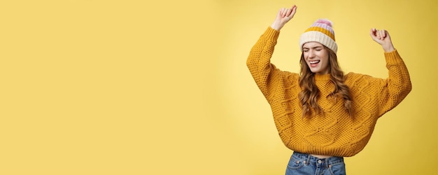 Oh yeah party vibe portrait joyful carefree dancing happy girl wearing winter hat sweater having fun