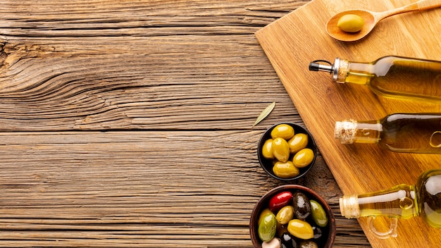 Oil bottles olive bowls and wooden spoon with copy space