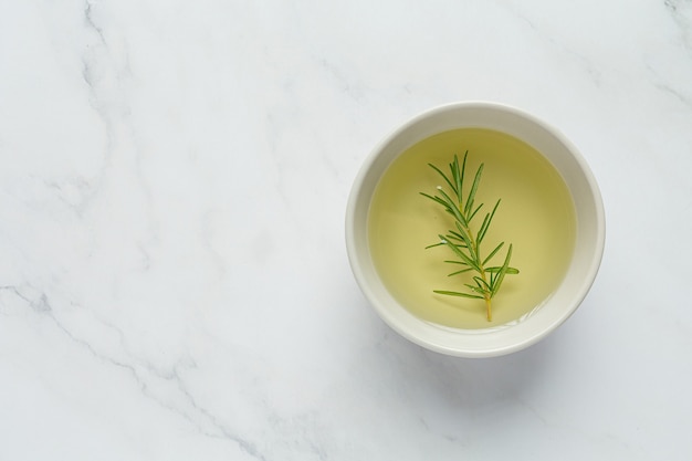 Oil with rosemary on table