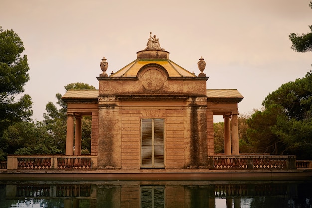 Old beautiful park building reflecting in a pond