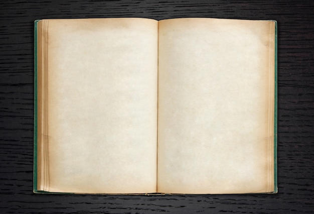 Free photo old book open on dark wood background