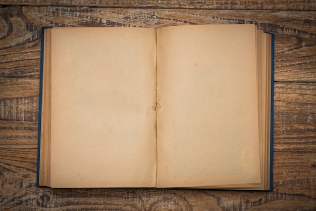 Free photo old book open on a wooden table seen from above