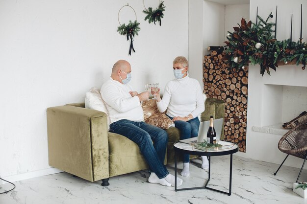 Old caucasian woman celebrates christmas with her husband at home during the quarantine