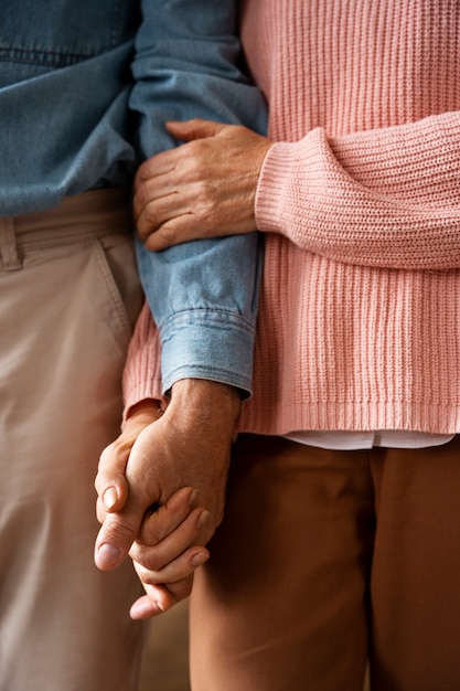 Old couple holding hands front view