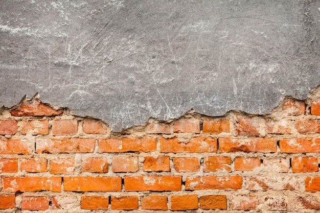 Free photo old and damaged plaster on red brick wall