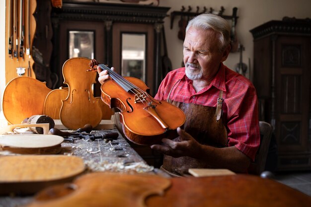 Old fashioned woodworker holding and admiring his masterpiece