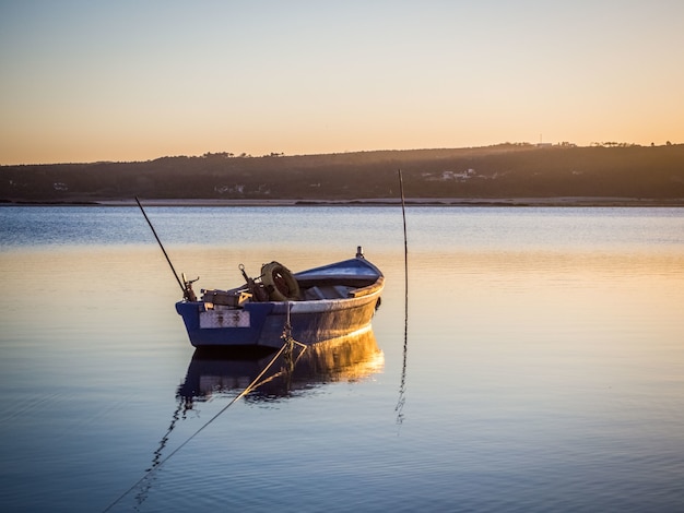 Old fishing boat at the river with the breathtaking view of the sunset