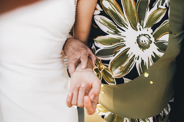 Free Photo old lady in green dress holds bride's hand tender