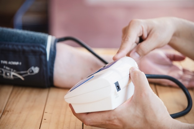 Free Photo old lady is being checked blood pressure using blood pressure monitor kid set