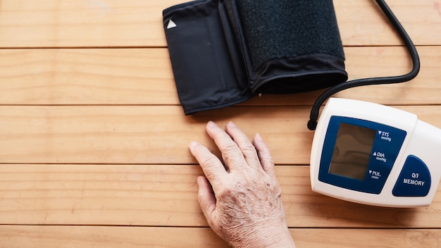 Old lady is being checked blood pressure using blood pressure monitor kid set 